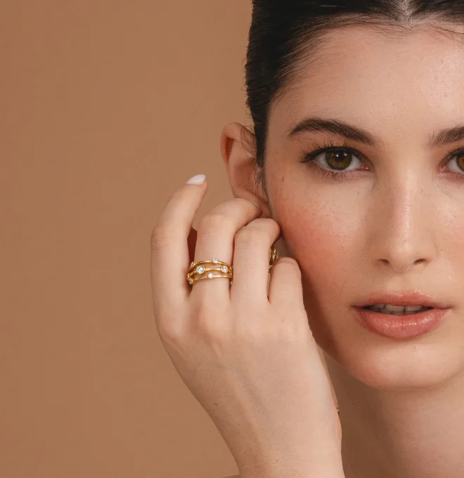 Woman wearing a variety of diamond and gemstone rings, bracelet, and necklace from Austen & Blake diamond jewelry collection
